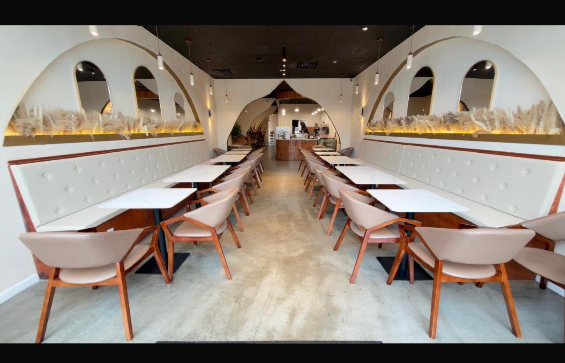 Safwa Somerset interior — arched alcoves, pampas grass, and marble tables